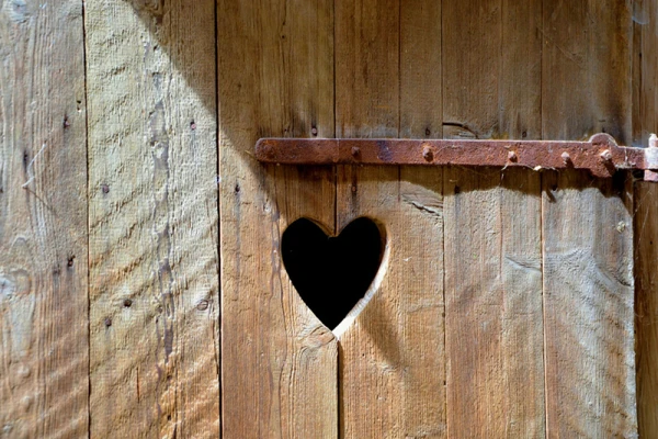 Une porte de cabane avec un coeur découpé